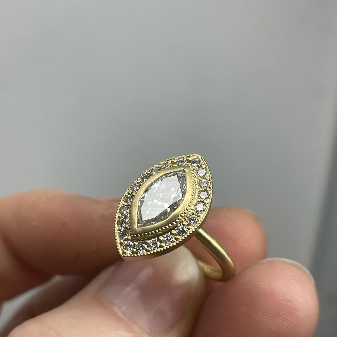 Close up detail of the intricate milgrain bezel and halo diamonds on a 3 CT marquise lab diamond ring