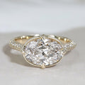 Top view of a 3 carat east west oval lab grown diamond ring with milgrain bezel frame