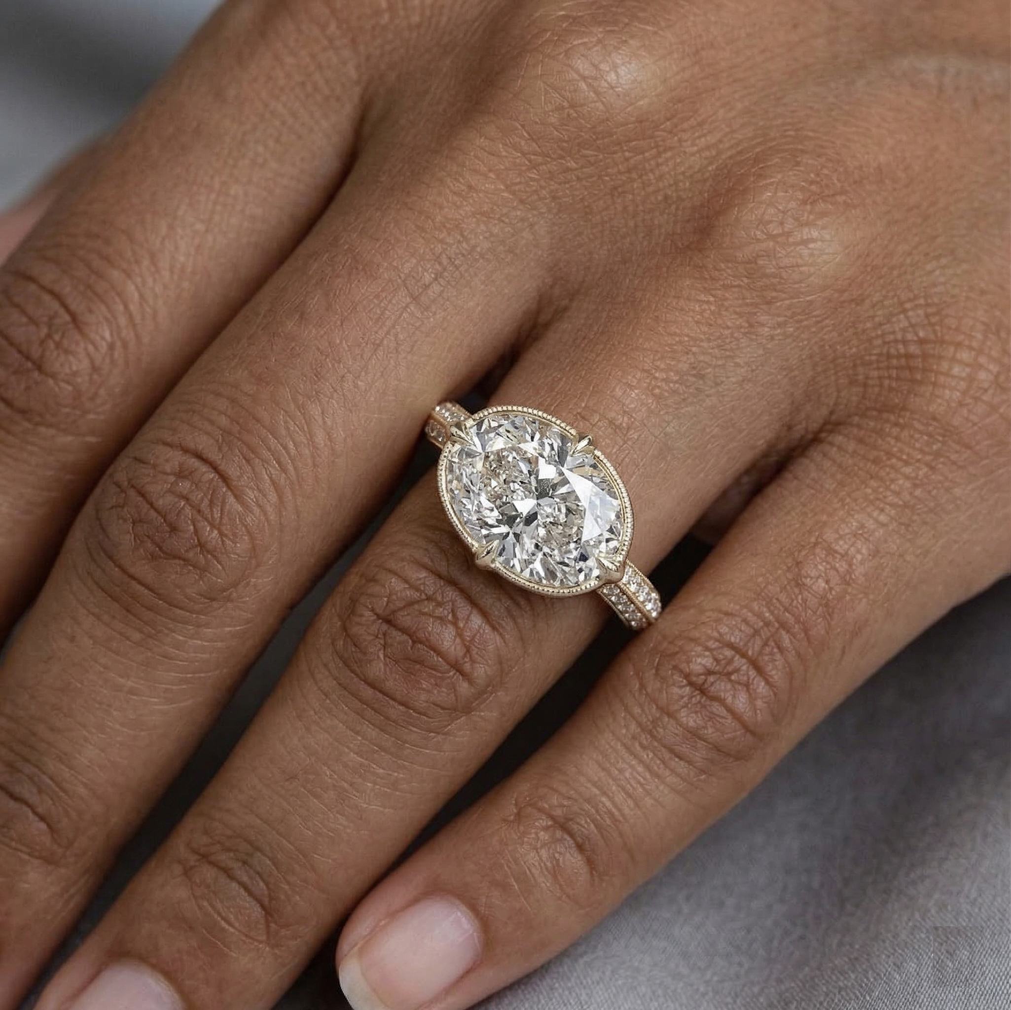 On-hand view of a 3 CT horizontal oval lab diamond ring featuring a vintage milgrain setting