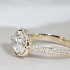 Close up side view of a 3ct oval lab diamond ring displaying the milgrain pave diamond band