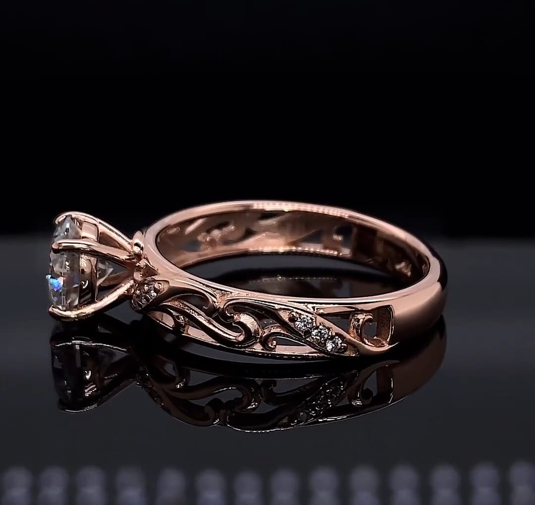 Side profile of 2 carat round lab diamond ring in rose gold showing filigree scrollwork band