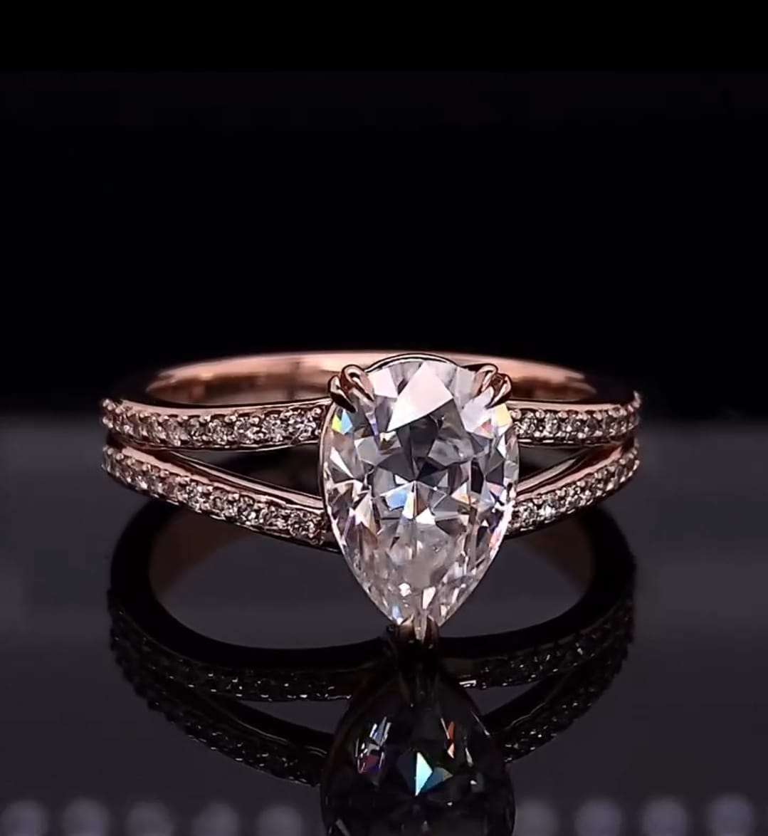 Front view of a 2 carat pear cut lab grown diamond ring with double row pave split shank in rose gold
