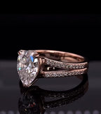 Three-quarter angle view highlighting the pavé diamond accents and pear center stone in rose gold