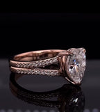 Detailed perspective view of a 2 carat teardrop pear cut diamond set on a rose gold double pave band