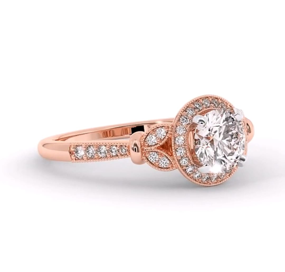Side profile of a 3 carat round lab grown diamond halo engagement ring in rose gold showing milgrain and leaf accents.