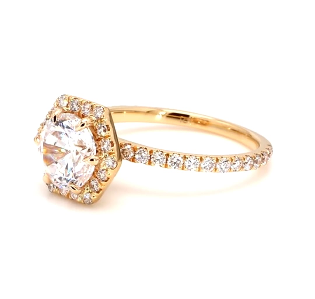 Angled view of a 2 carat round lab grown diamond ring with hexagon halo and pave band.