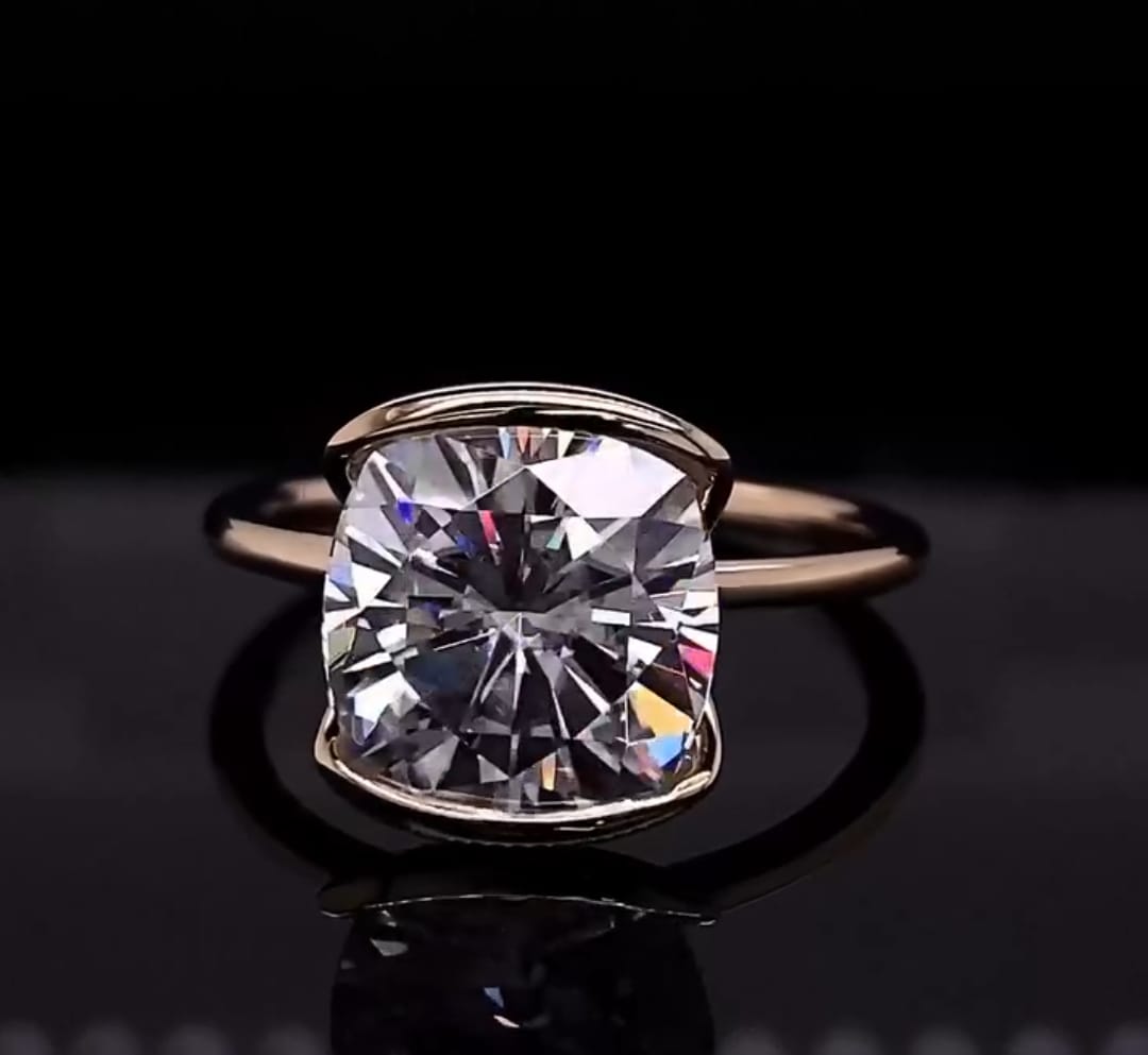 Front view of a 3 CT cushion cut lab grown diamond solitaire ring in a modern half-bezel gold setting.