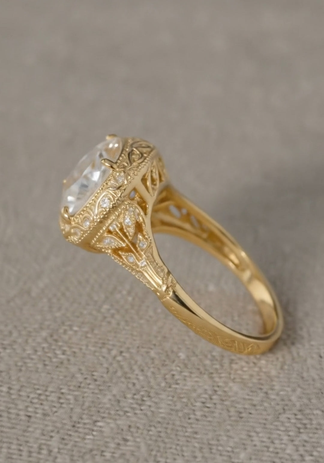Side profile of a vintage-style yellow gold ring showcasing a high openwork gallery, milgrain edges, and intricate leaf motif filigree with diamond accents on the shoulders.