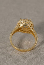Under-gallery view of a yellow gold ring revealing the structural openwork basket design and deeply engraved patterns along the shank.