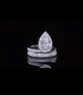Front view of a 2 CT pear cut lab grown diamond ring with micro-pave halo and bypass band.
