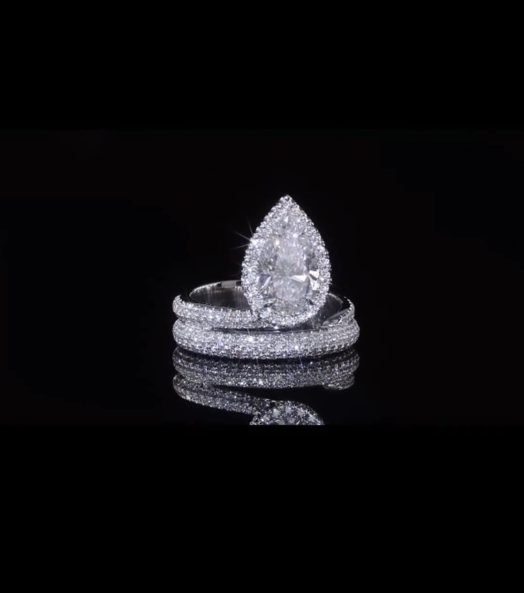 Front view of a 2 CT pear cut lab grown diamond ring with micro-pave halo and bypass band.
