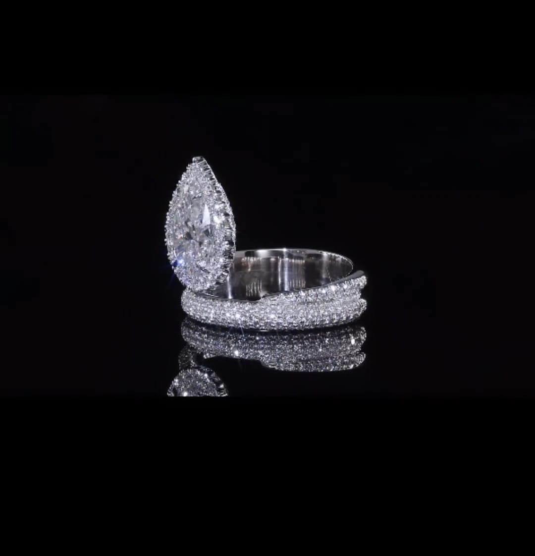 Side view showing the elevated pear-shaped halo setting and brilliant pave detailing.