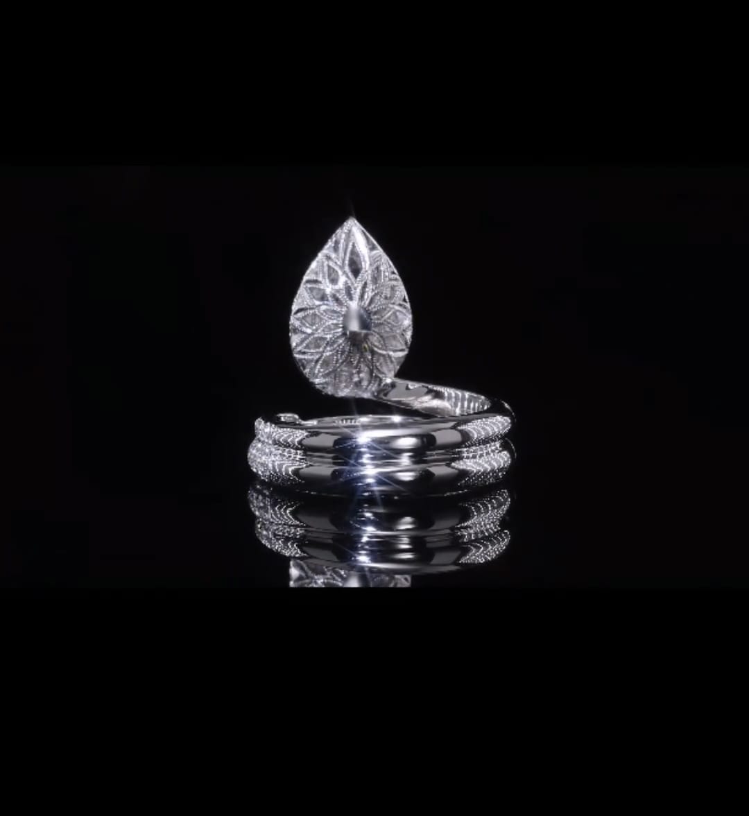 Direct reverse view of the intricate floral filigree pattern under the pear-shaped diamond setting.