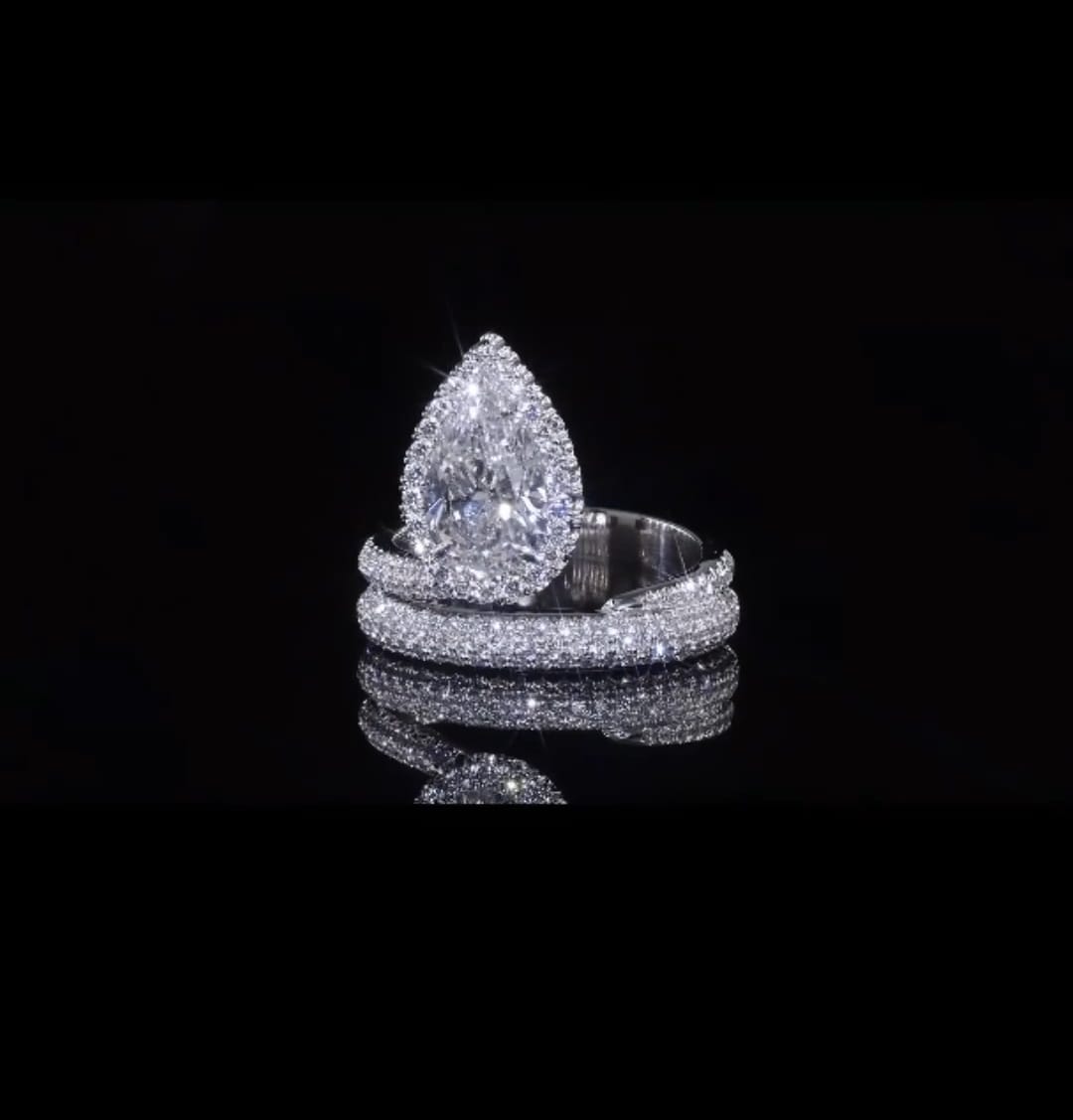 High-shine front angle of 2 CT pear lab grown diamond engagement ring on black reflective background.