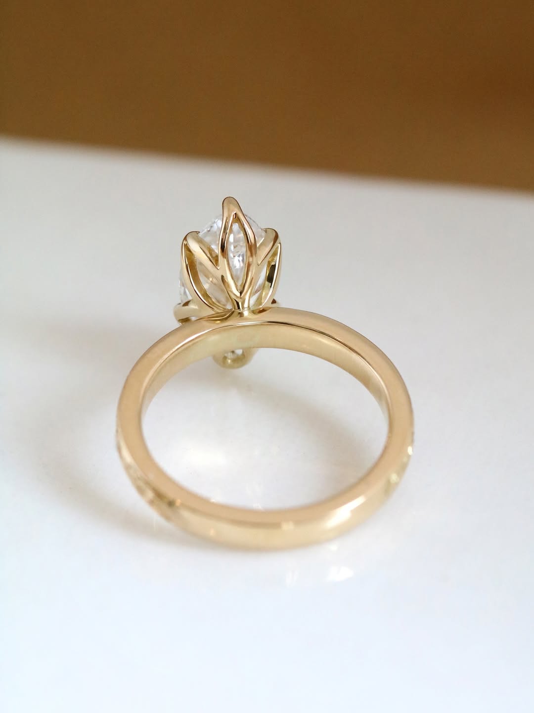 Side profile of 3 carat marquise lab grown diamond ring showing unique floral basket setting in yellow gold