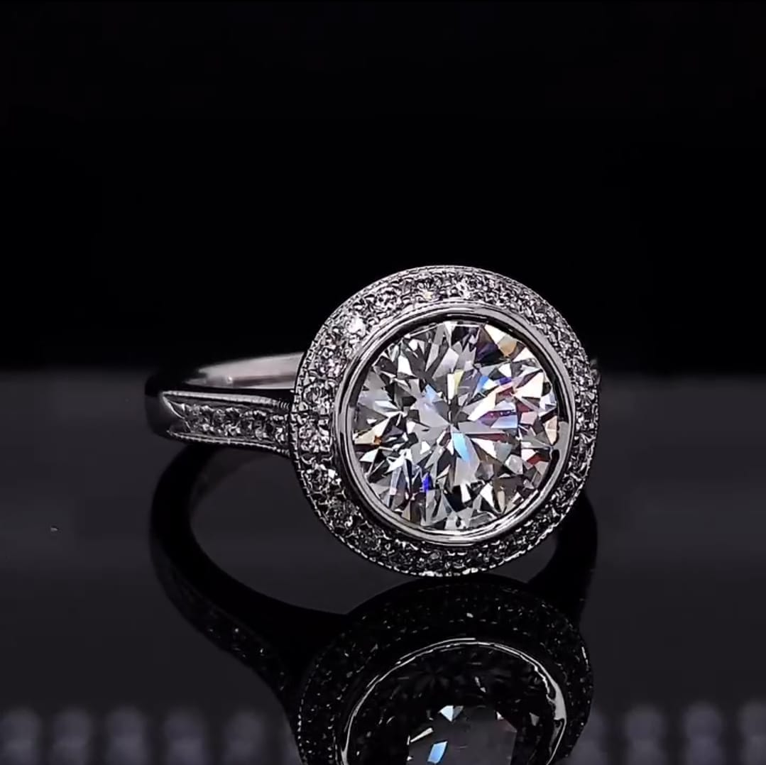 Top down view of a 3 carat round cut lab grown diamond engagement ring with a bezel halo setting.