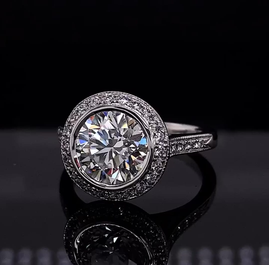 Close-up front view of a sparkling 3 carat round brilliant lab grown diamond in a delicate halo setting.
