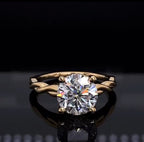 Front view of a 2 carat round cut lab grown diamond engagement ring featuring a twisted yellow gold band.