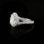 Side profile view of a 2 CT oval cut lab grown diamond halo ring with a diamond split shank band on a black background.