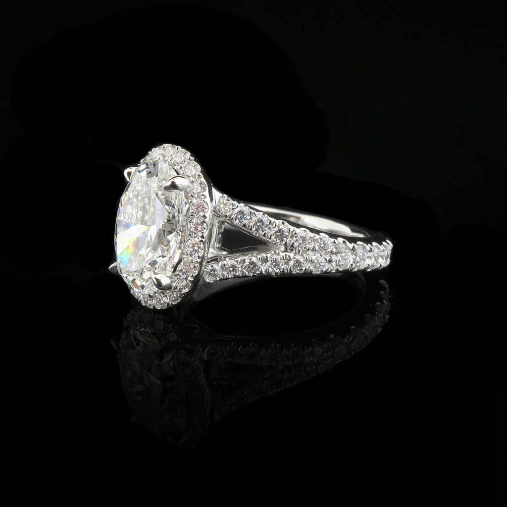 Side profile view of a 2 CT oval cut lab grown diamond halo ring with a diamond split shank band on a black background.