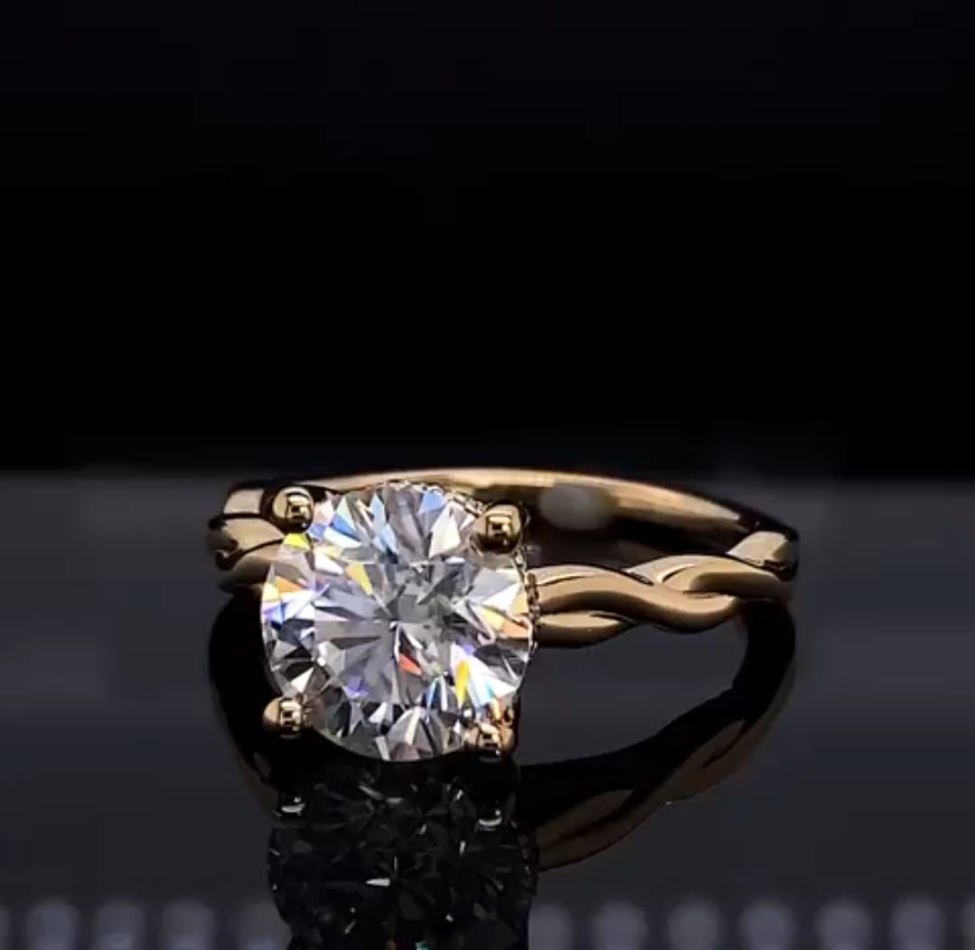 Close-up front perspective highlighting the brilliant facets of a 2 carat round lab diamond in a 4-prong yellow gold setting.