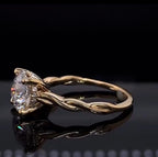 Profile view of a twisted vine diamond engagement ring, detailing the intricate gold metalwork and sparkling hidden halo.