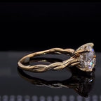 Side angle of a 2 CT round lab grown diamond ring showing the elegant intertwined yellow gold band design.