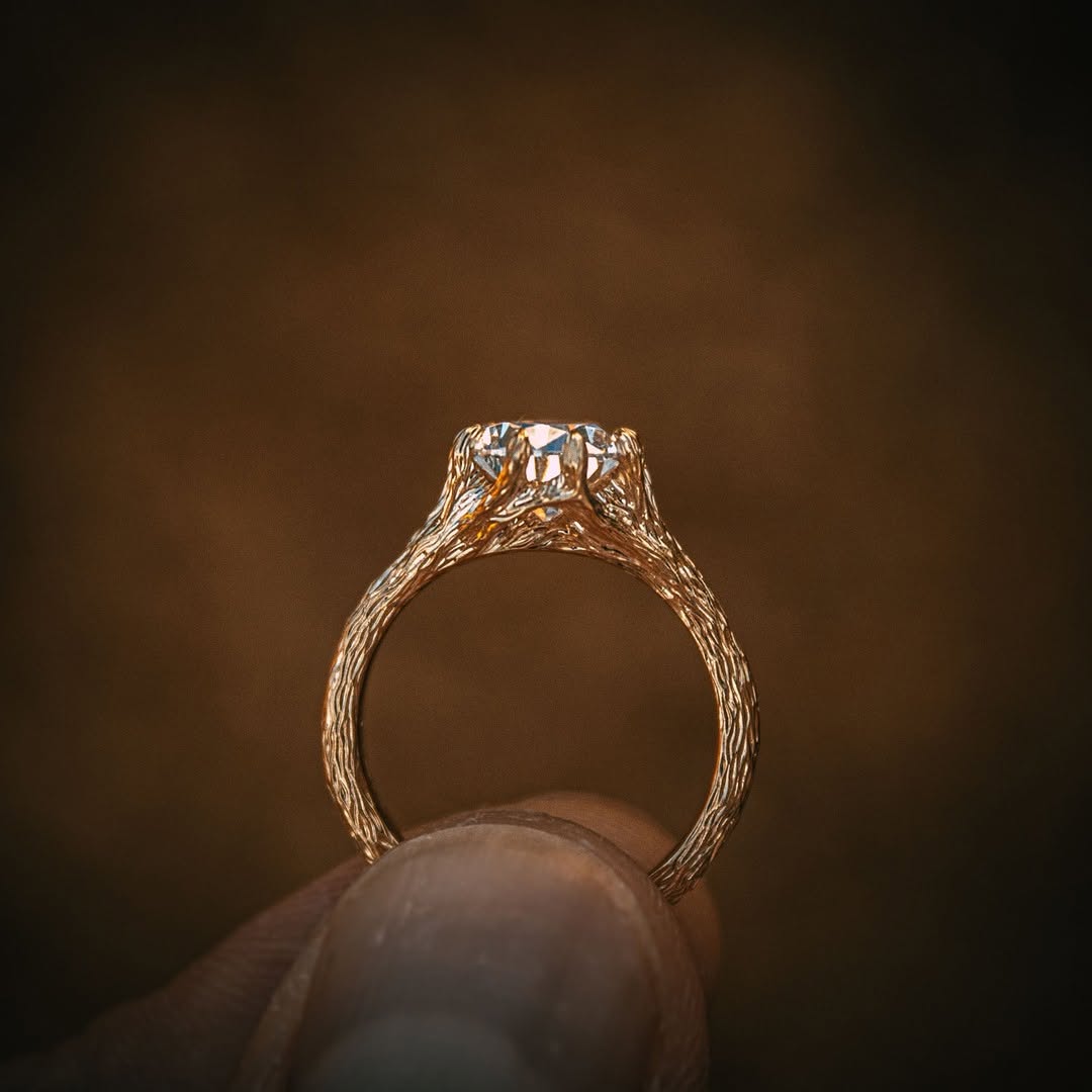 Side profile view of a 2 CT pear cut lab grown diamond ring featuring a uniquely textured twig-style gold band.