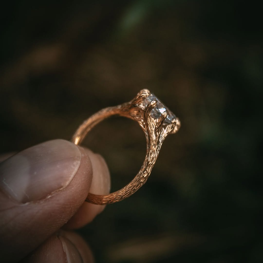 Angled view of a nature-inspired 2 CT pear shape lab grown diamond ring featuring an intricate branch and bark band texture.