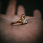2 Carat pear cut lab-created diamond ring resting elegantly on a palm, showing the organic, detailed gold twig band.