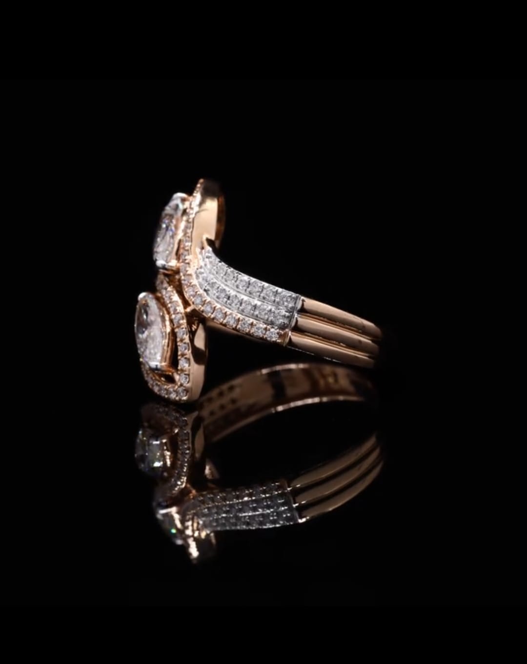 Side profile of a two-stone diamond engagement ring highlighting the sparkling split shank pave band and curved setting.