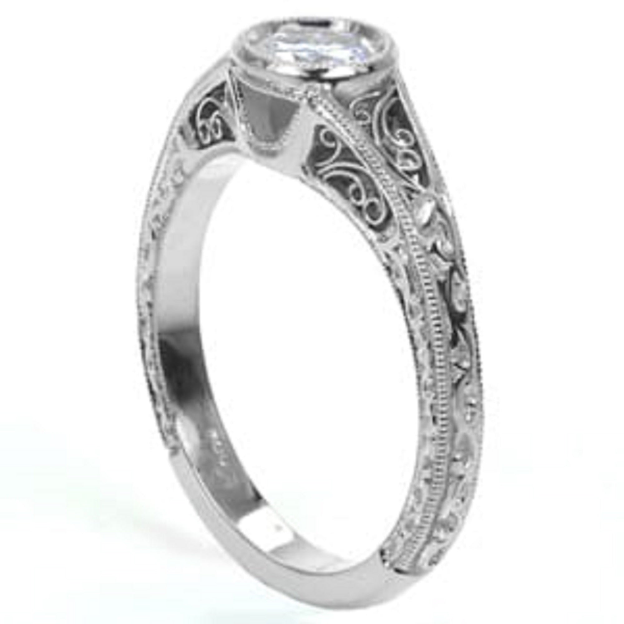 Close-up of a woman's hand wearing a beautiful vintage-inspired round bezel engagement ring with an intricate filigree band.
