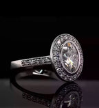 Angled top view of a 3 carat oval cut lab grown diamond in a protective bezel halo setting with a diamond pavé band.