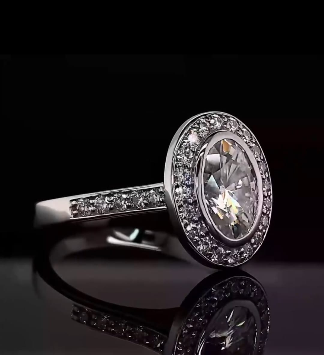 Angled top view of a 3 carat oval cut lab grown diamond in a protective bezel halo setting with a diamond pavé band.