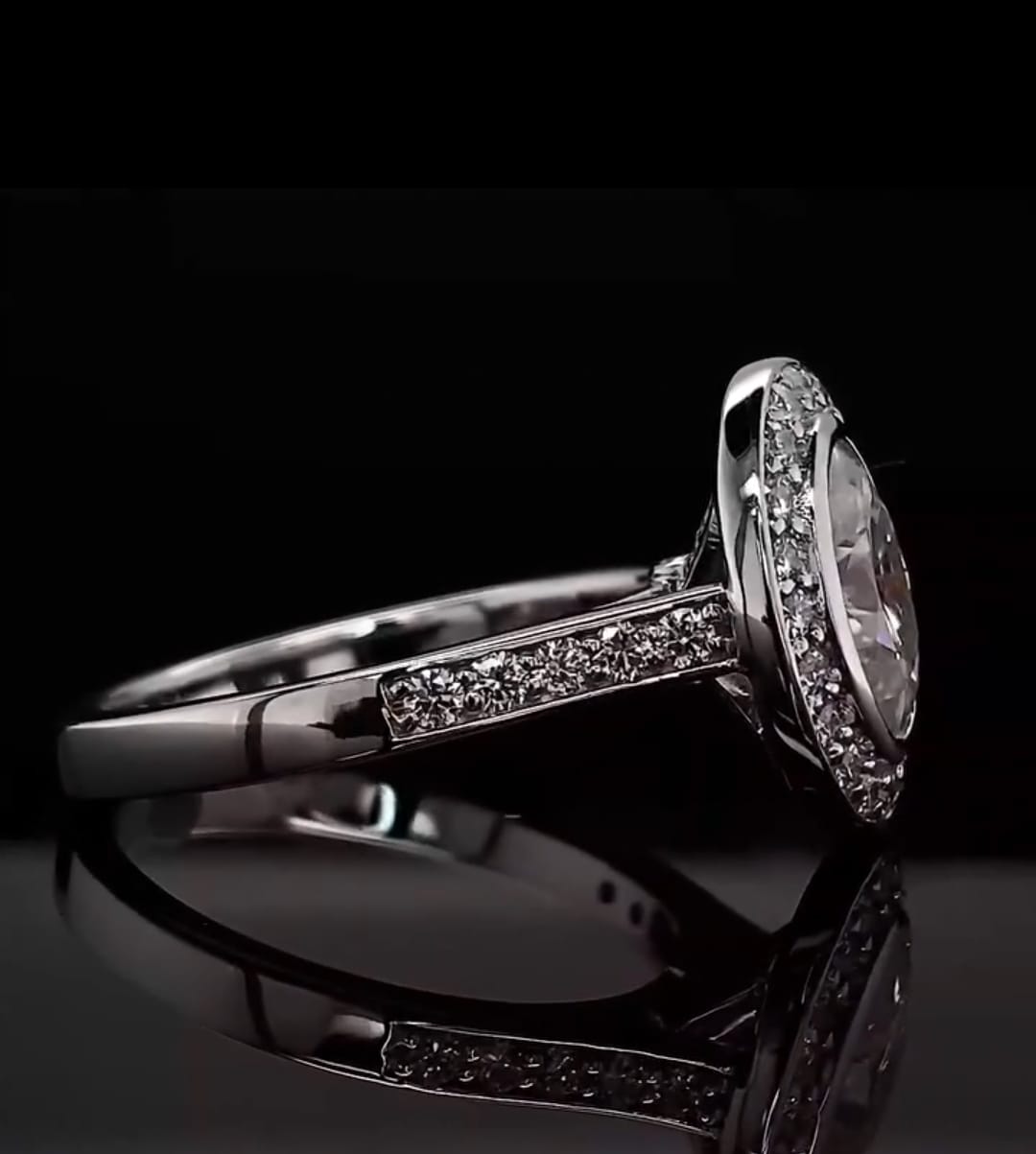 Profile view of a 3 CT oval lab diamond ring resting on a black surface, highlighting the brilliant pavé diamonds set along the ring's shoulders.