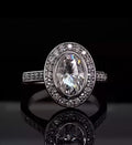 Direct top-down view of a brilliant 3 carat oval lab grown diamond engagement ring with a seamless bezel and diamond halo.