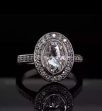 Direct top-down view of a brilliant 3 carat oval lab grown diamond engagement ring with a seamless bezel and diamond halo.