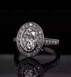 Close-up top view of a stunning 3 carat oval cut lab diamond ring showing the vibrant fire of the center stone and the sparkling pavé halo.