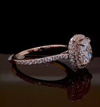 Low-angle side view of a rose gold cushion cut engagement ring showing the delicate pavé diamonds on the band.