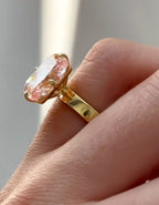 Angled side view showcasing the sleek flat yellow gold band and the deep, brilliant facets of the 3 carat pink radiant diamond.