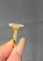 Straight-on side profile of a marquise cut diamond ring highlighting the secure prong setting and the intricately engraved gold band.