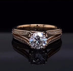 Front view of a 2 carat round cut lab grown diamond engagement ring featuring a twisted diamond pavé split shank on a reflective black background.