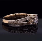 Side profile view of a round cut diamond engagement ring highlighting the polished metal band and sweeping pavé diamond accents.