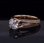 Three-quarter view of a sparkling 2 carat round diamond in a prong setting with a diamond-accented split shank band.