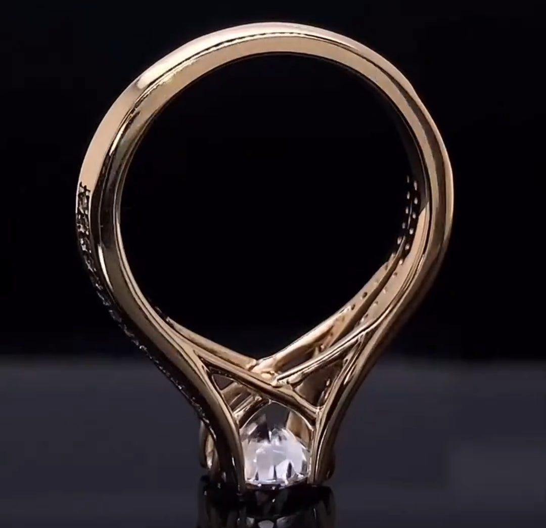 Bottom-up profile view highlighting the open under-gallery beneath the center round cut diamond of the engagement ring.