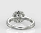 Bottom-up view of a 3 carat round cut lab grown diamond ring showcasing a delicate open floral petal under-gallery in white metal.
