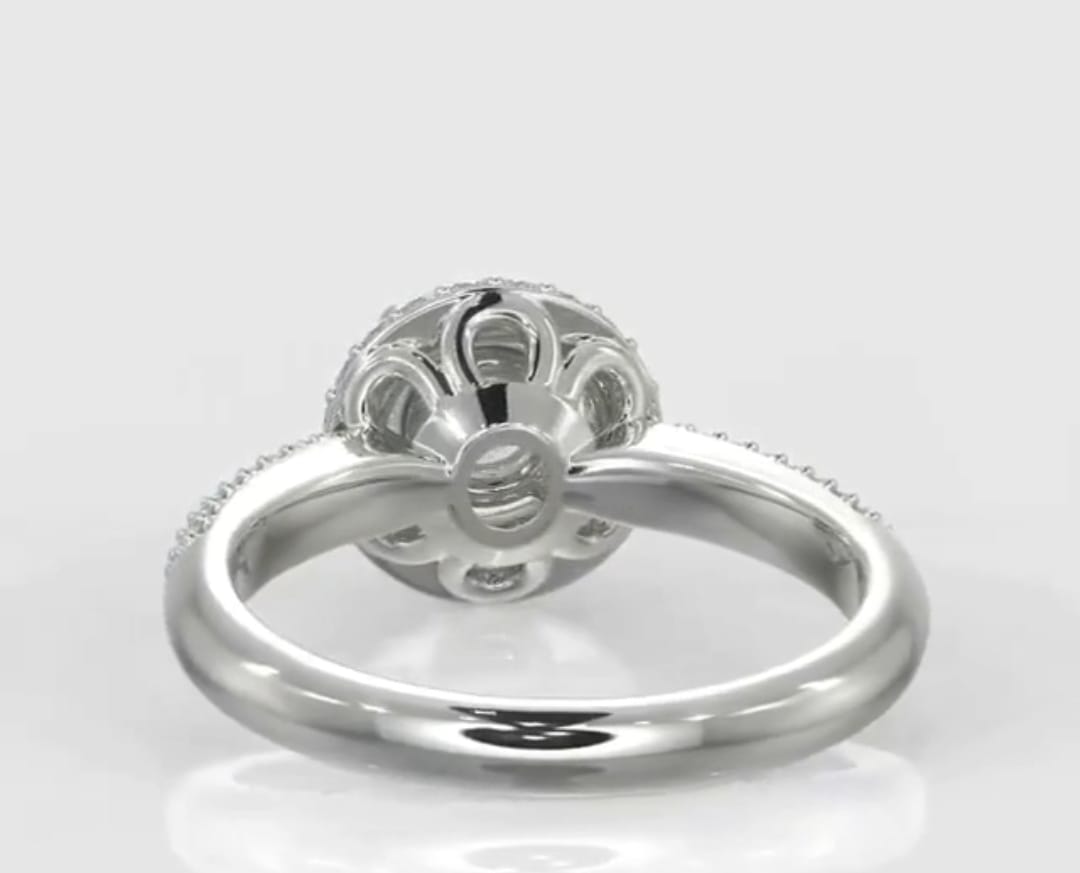 Bottom-up view of a 3 carat round cut lab grown diamond ring showcasing a delicate open floral petal under-gallery in white metal.