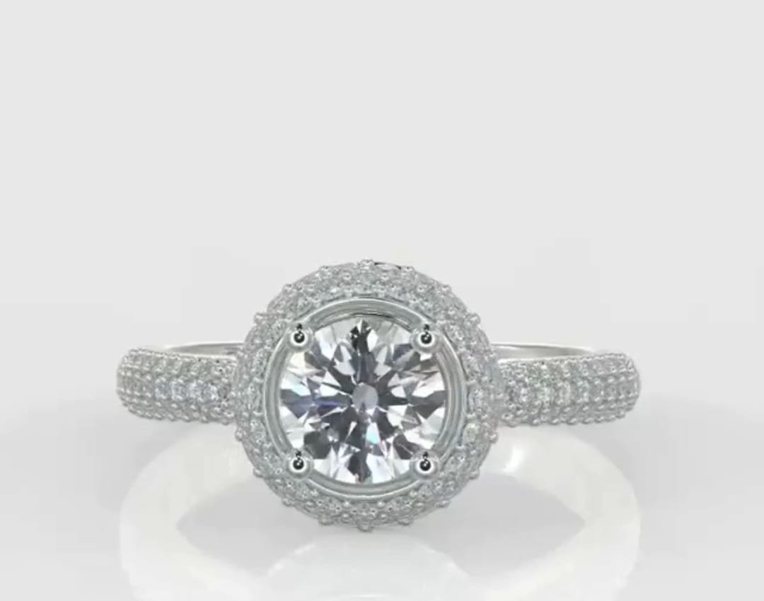 Top-down view of a stunning 3 carat round cut lab created diamond surrounded by a dazzling pavé halo and diamond shank.