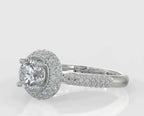 Angled top view showcasing the secure four-prong center round diamond setting, brilliant halo, and glittering pavé band.