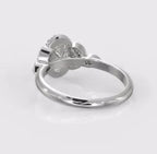 Angled rear profile of an oval diamond engagement ring highlighting the vintage-inspired leaf motif shoulders with delicate milgrain detailing.